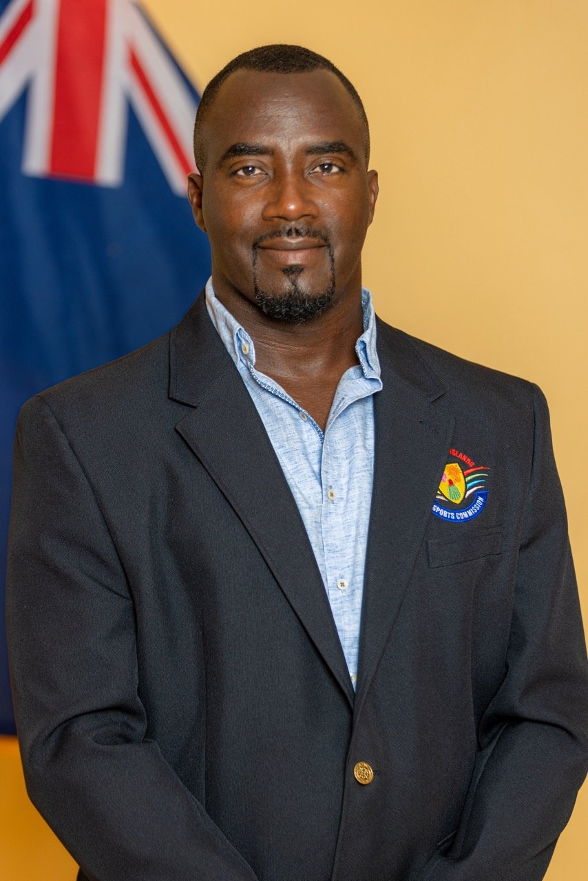 Shanwell Gardiner, founder and Medical Technologist of AccuDiagnostics, in front of the Turks and Caicos Islands flag.